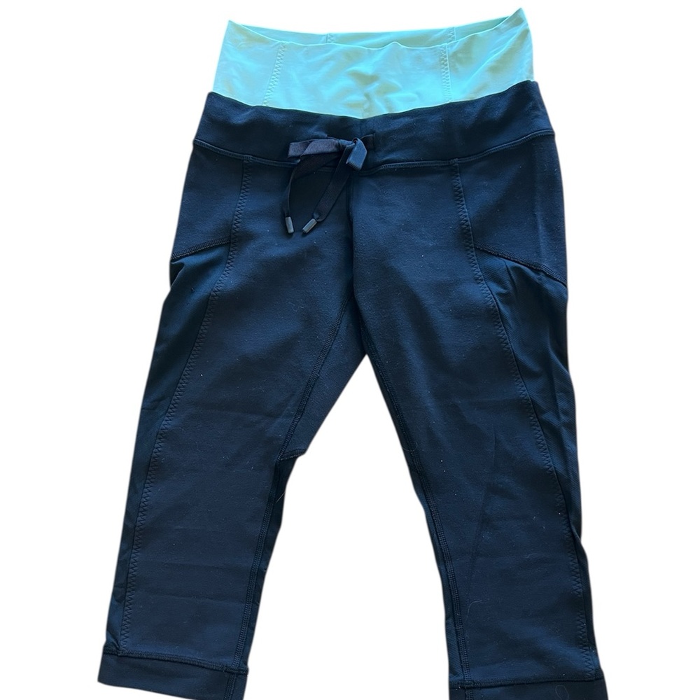 Lululemon black cropped athletic leggings featuring a contrasting mint waistband
